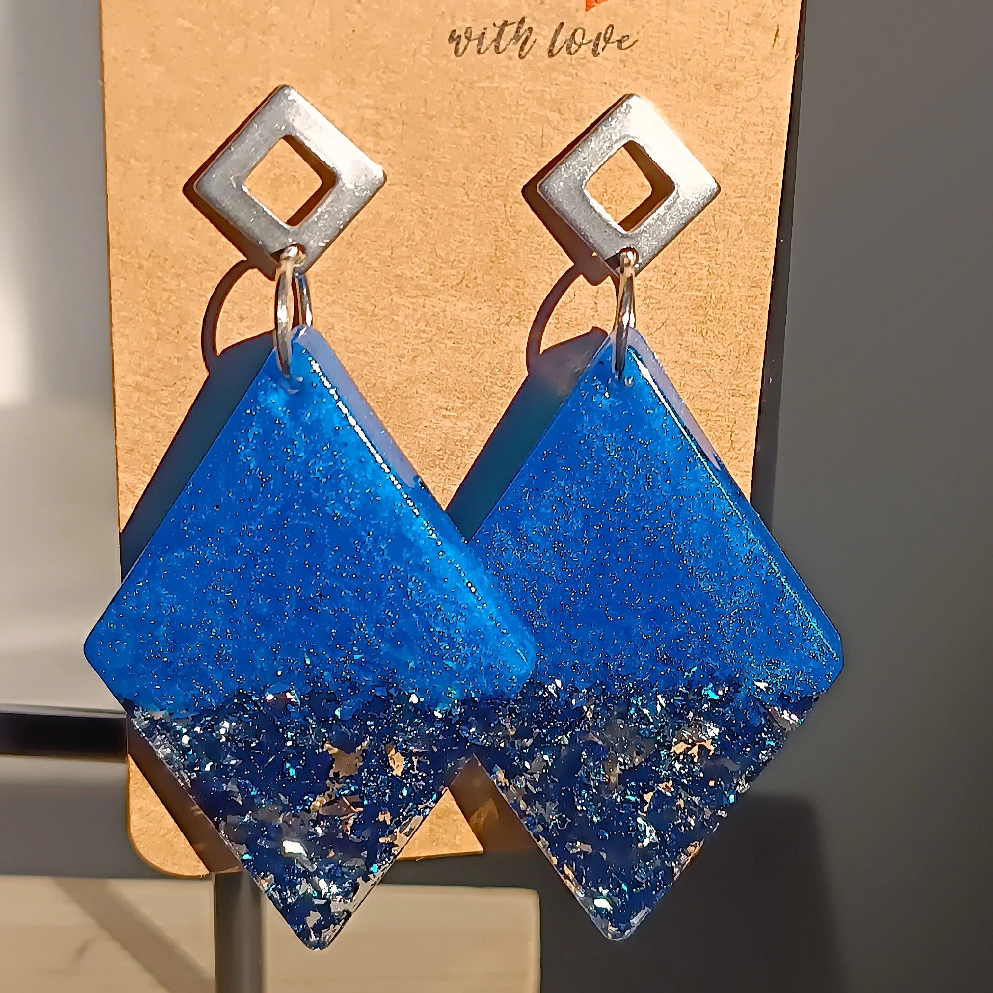 Boucles d’oreilles grand losange en résine UV bleue et feuilles de métal argentées