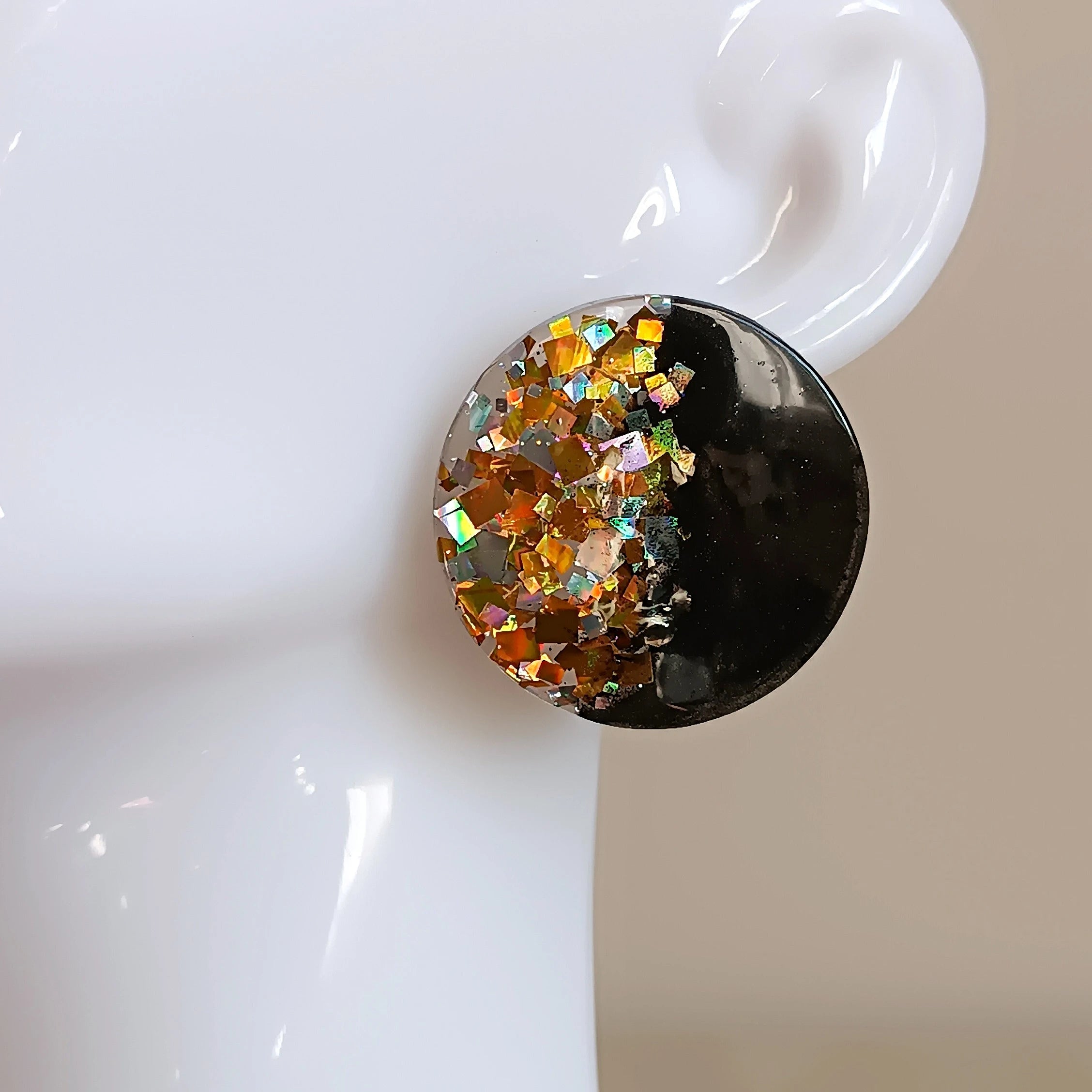 Boucles d’oreilles rondes en résine UV noire avec inclusions de paillettes argent et or, création artisanale