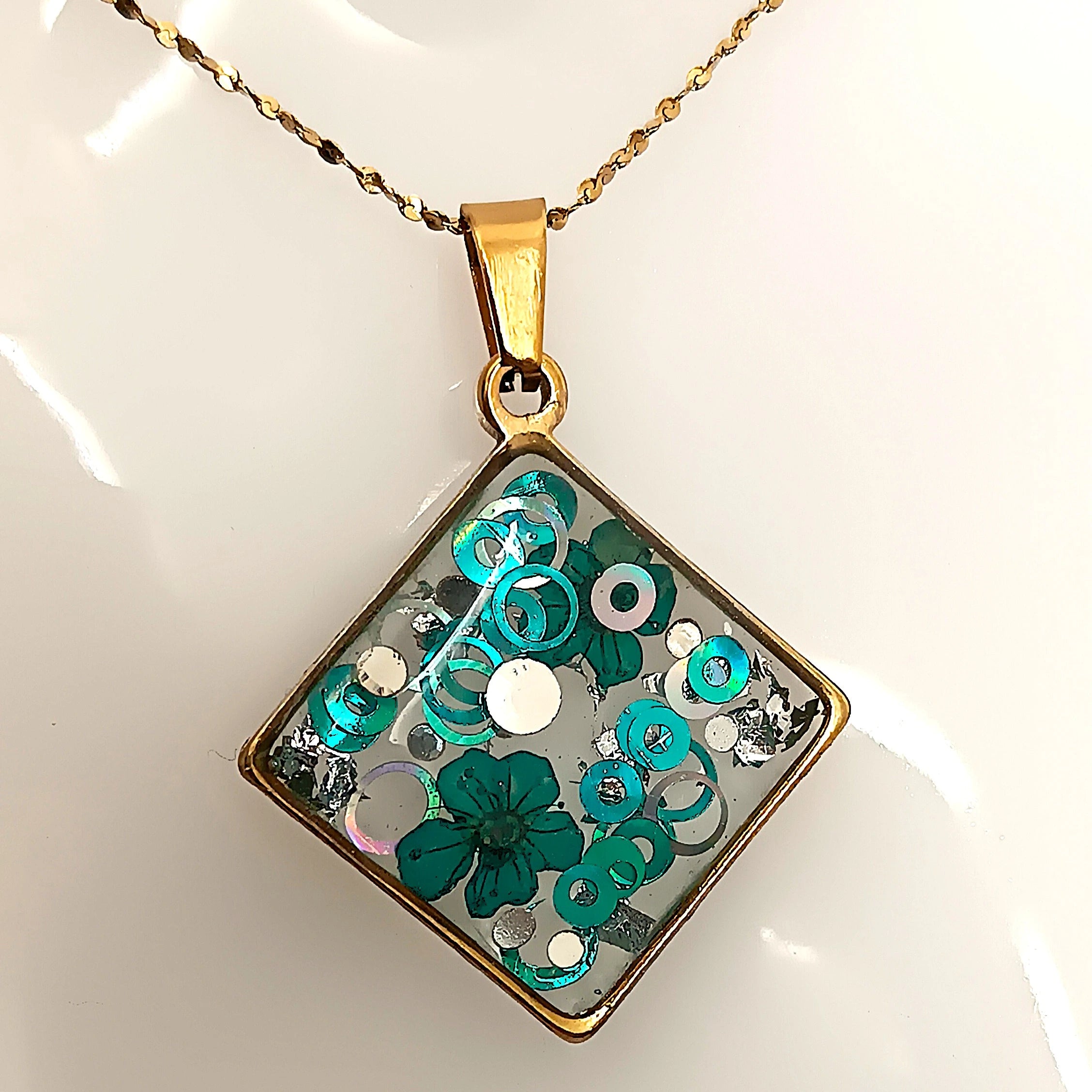 Collier losange en acier inoxydable avec pendentif en résine UV pailletée bleue et argentée, décor fleur, fait main