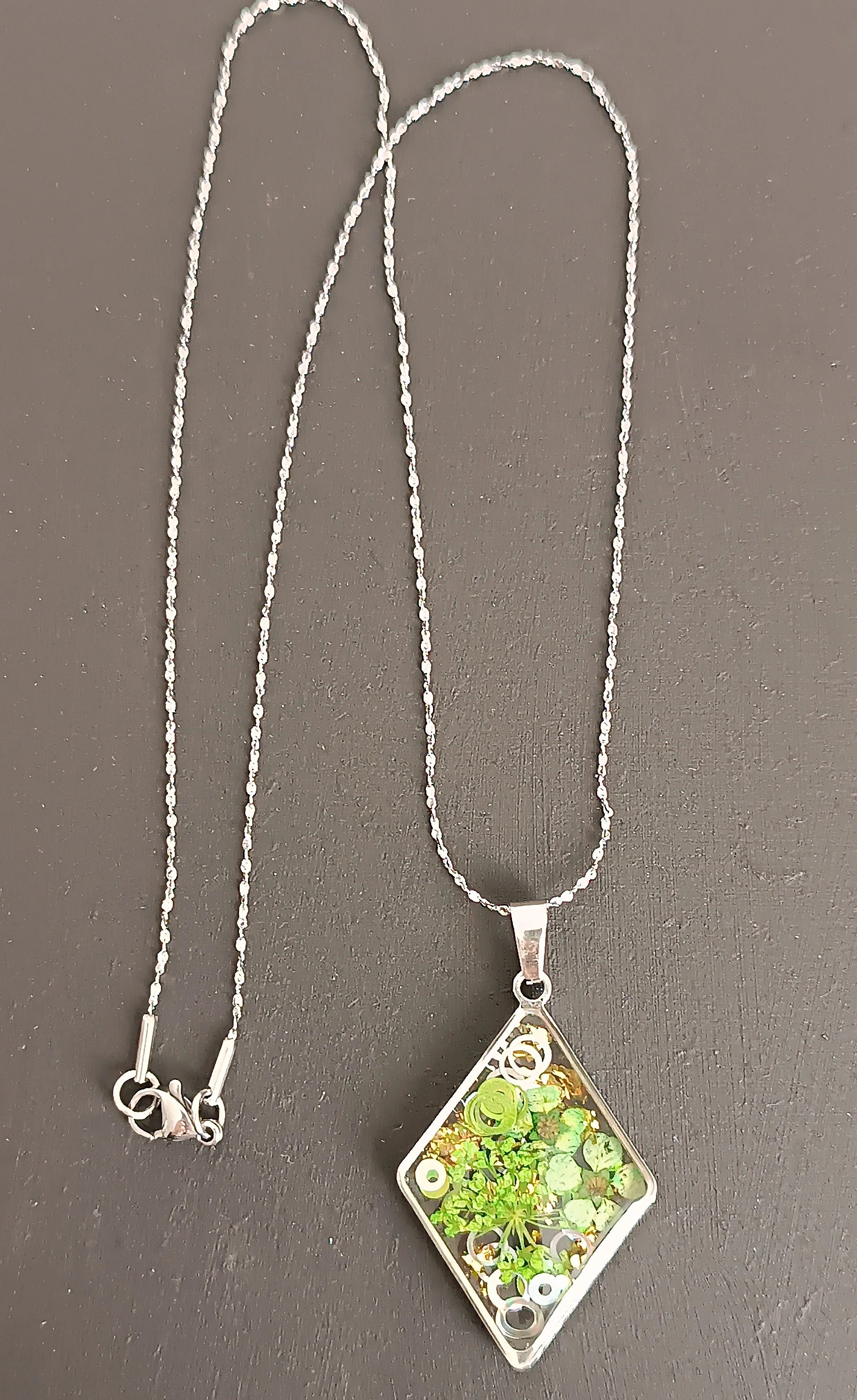Collier losange en résine UV verte avec paillettes argentées et fleurs, bijou artisanal